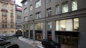 A modern building with large windows and a parking area in front. - Aparthotel Wenceslas (Prague)