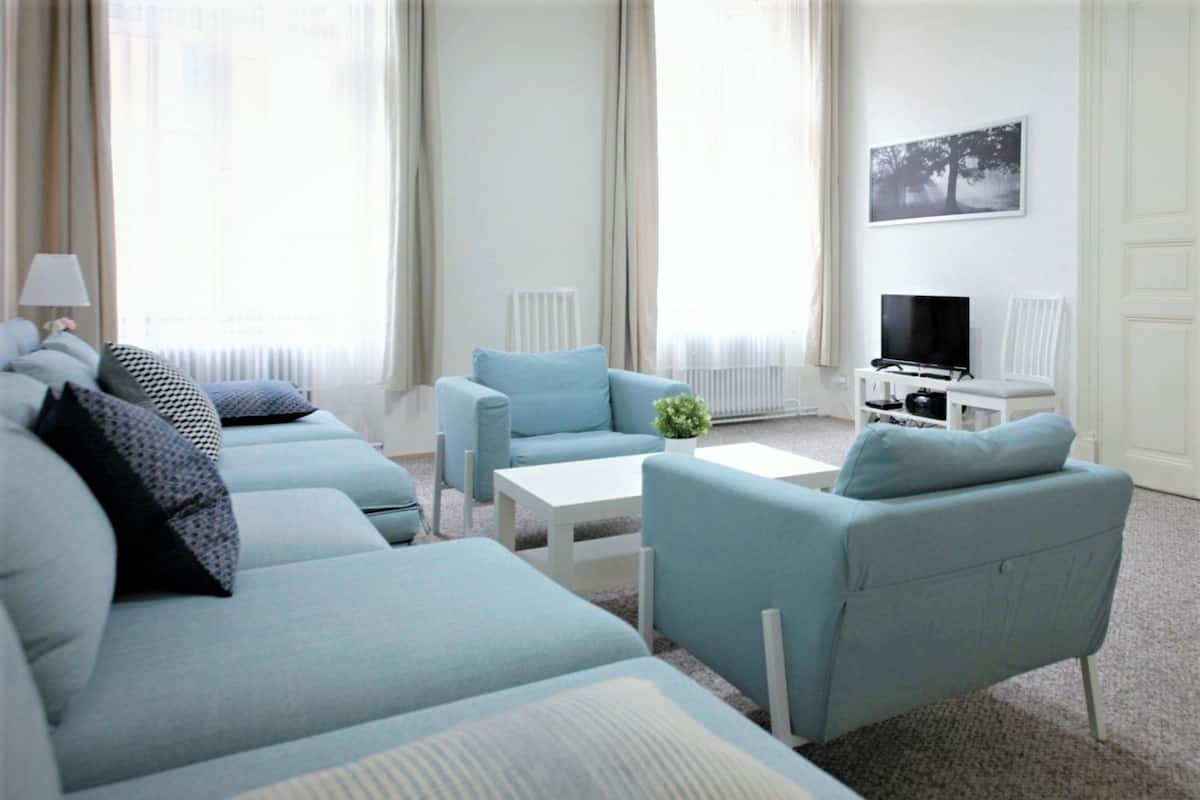 A modern living room with a sofa set, a coffee table, and a TV.