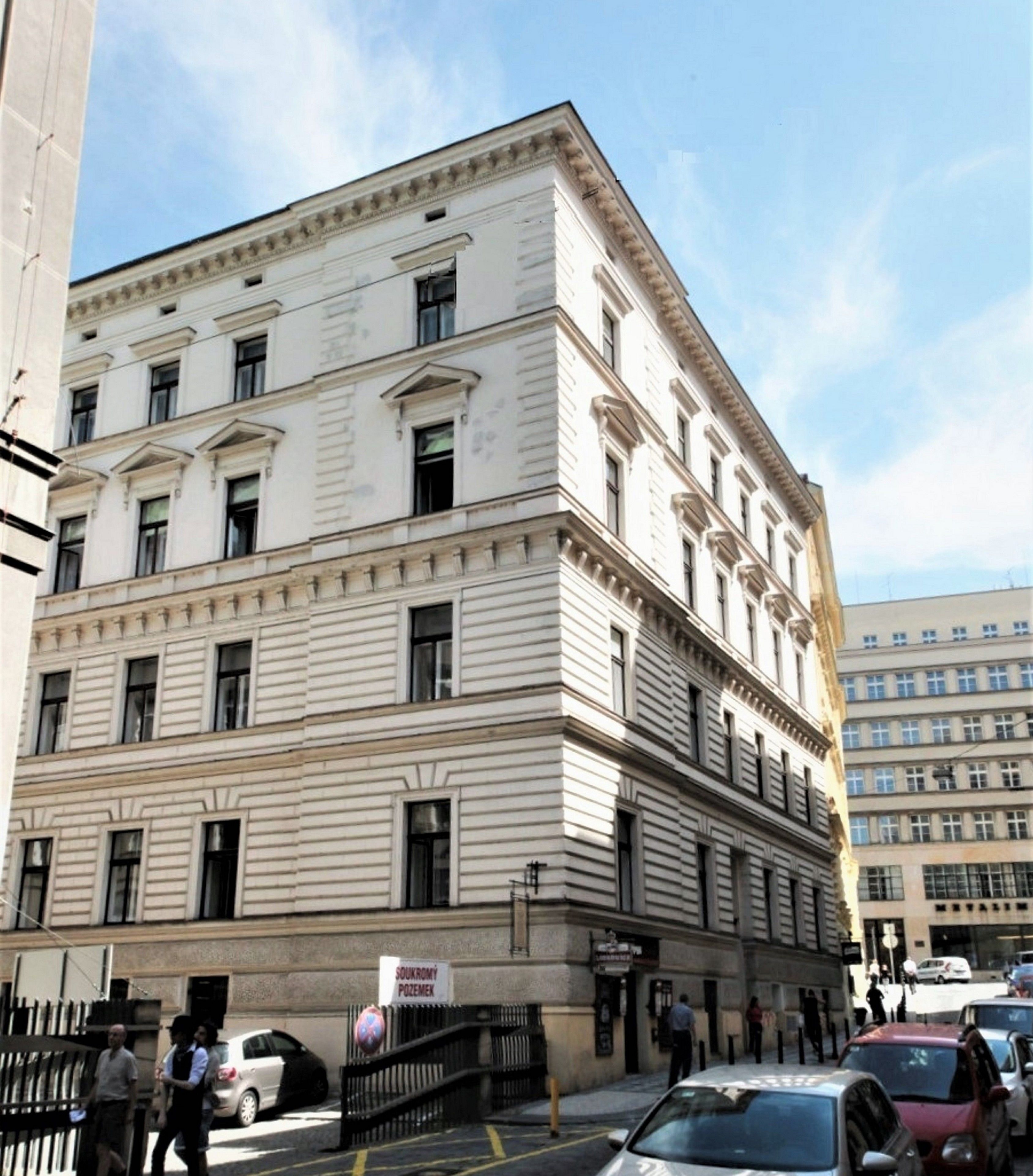 A multi-story building with a classical architectural style, featuring a symmetrical facade with evenly spaced windows and decorative moldings.