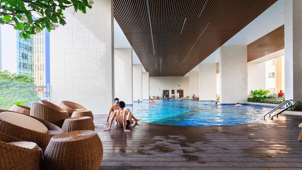 Une piscine intérieure dotée de sièges en osier et d’un design moderne au niveau du plafond.
