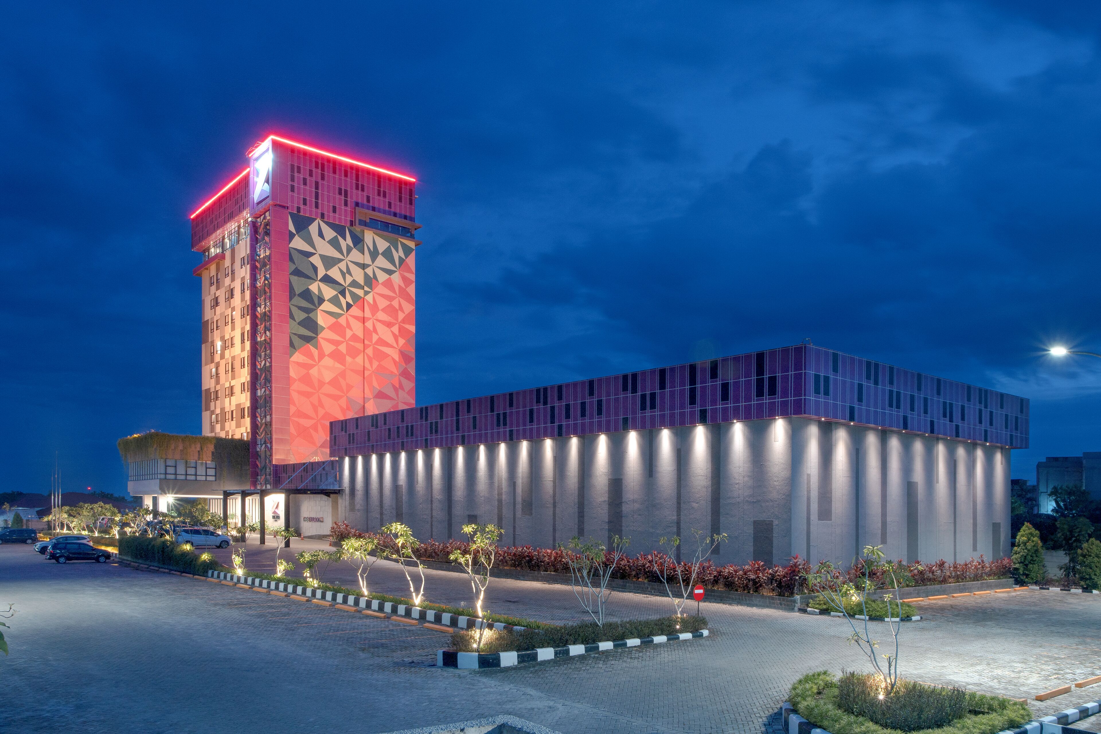 A modern building with a tall tower and a shorter rectangular structure.