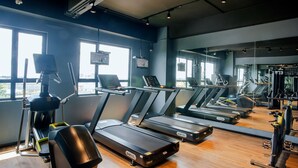 A gym with treadmills, exercise bikes, and a mirrored wall. - The Zuri Dumai (Dumai)