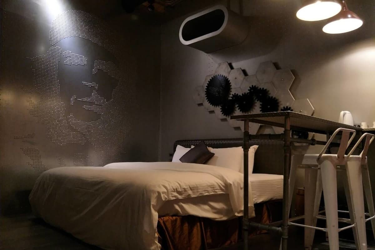Un dormitorio con una cama, un escritorio y una silla.