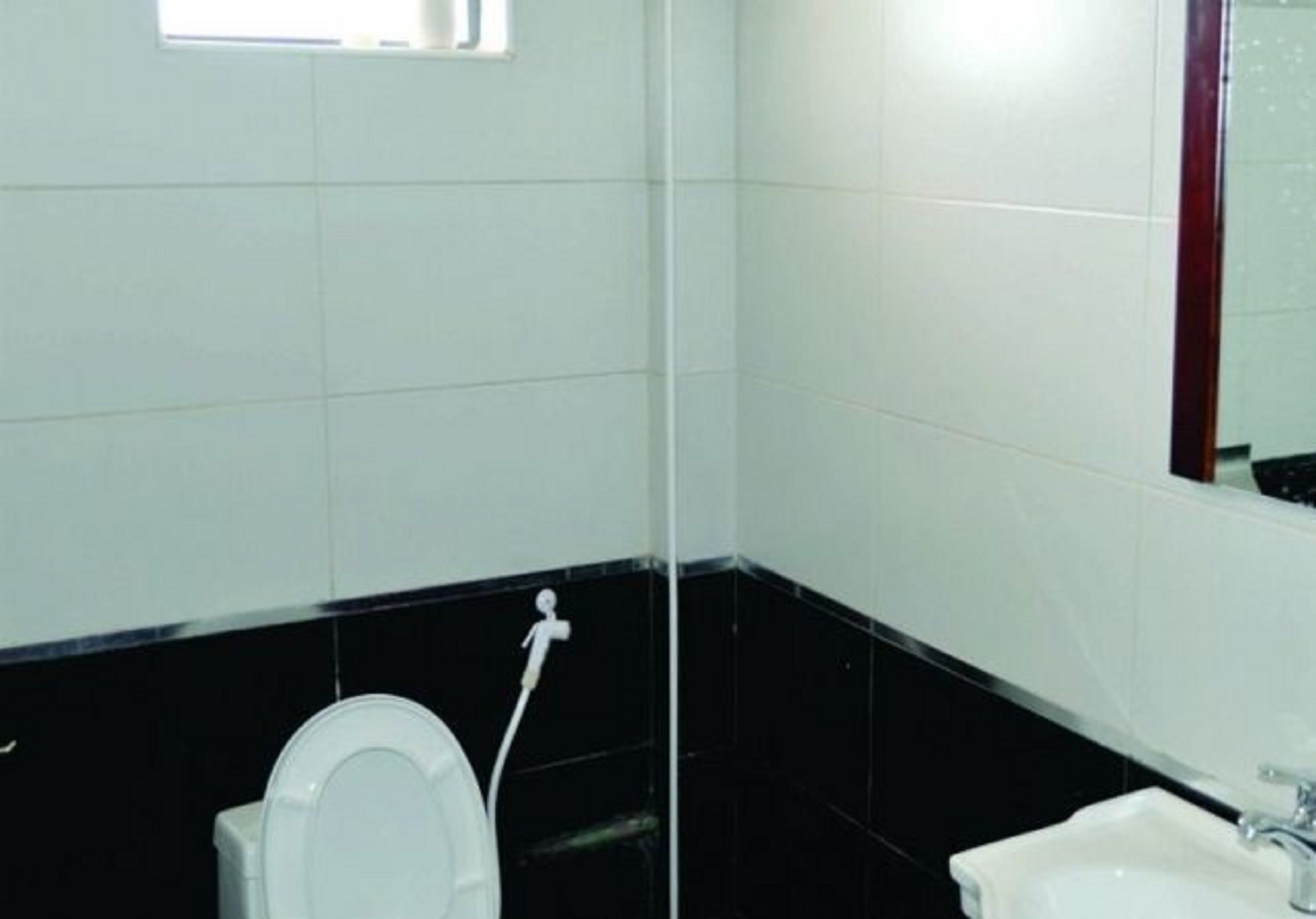 Ein Badezimmer mit Toilette, Waschbecken und Spiegel.