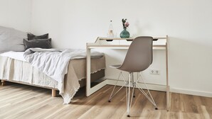 Un dormitorio con cama, escritorio y silla.