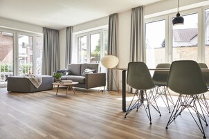Una sala de estar moderna con un sofá, una mesa de centro y un comedor con sillas.