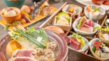 A variety of dishes including a hot pot with meatballs and vegetables, and several small bowls with different foods.