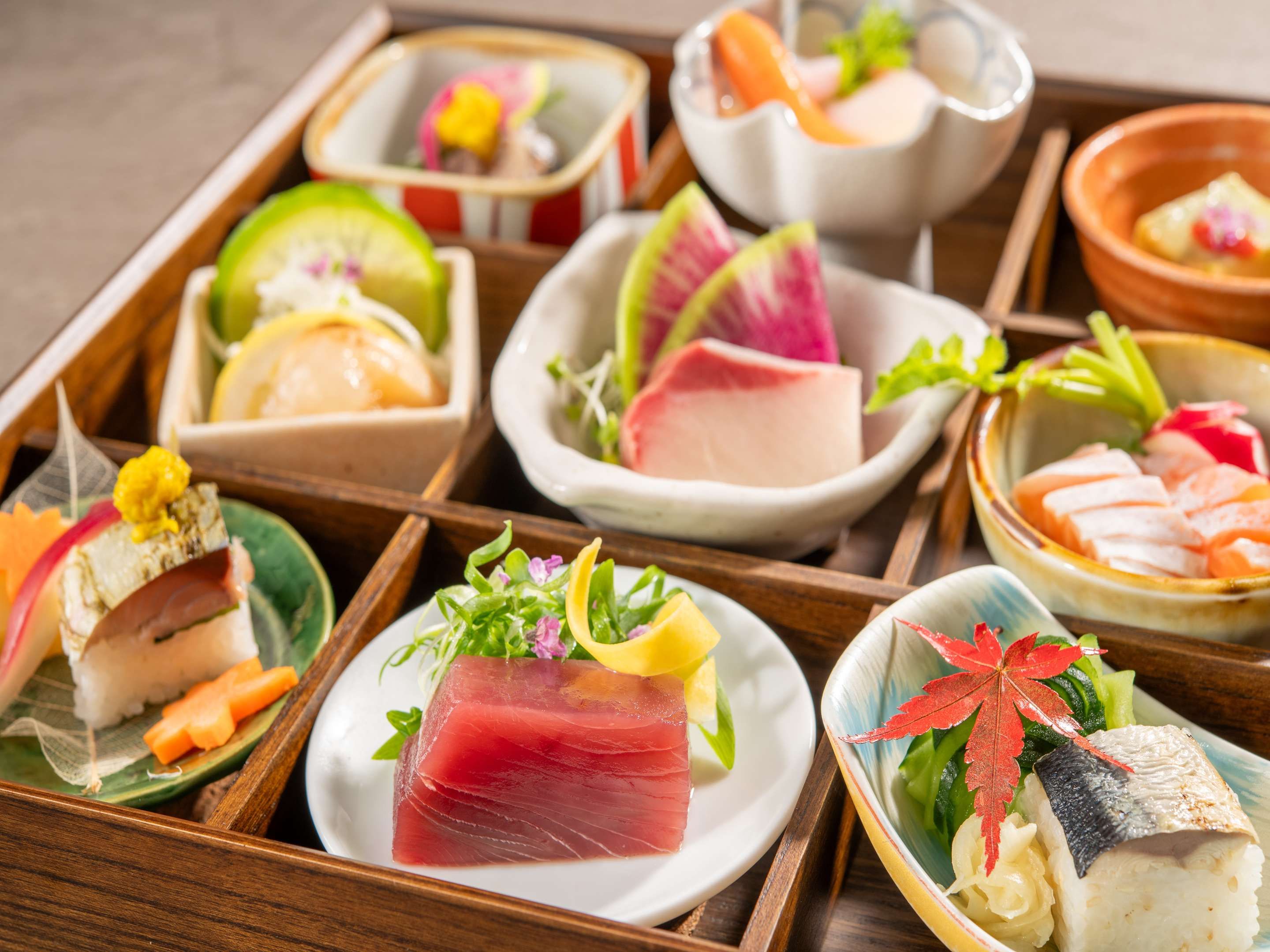 Verschiedene Sushi-Gerichte, anmutig auf einer Holzschale angeordnet.