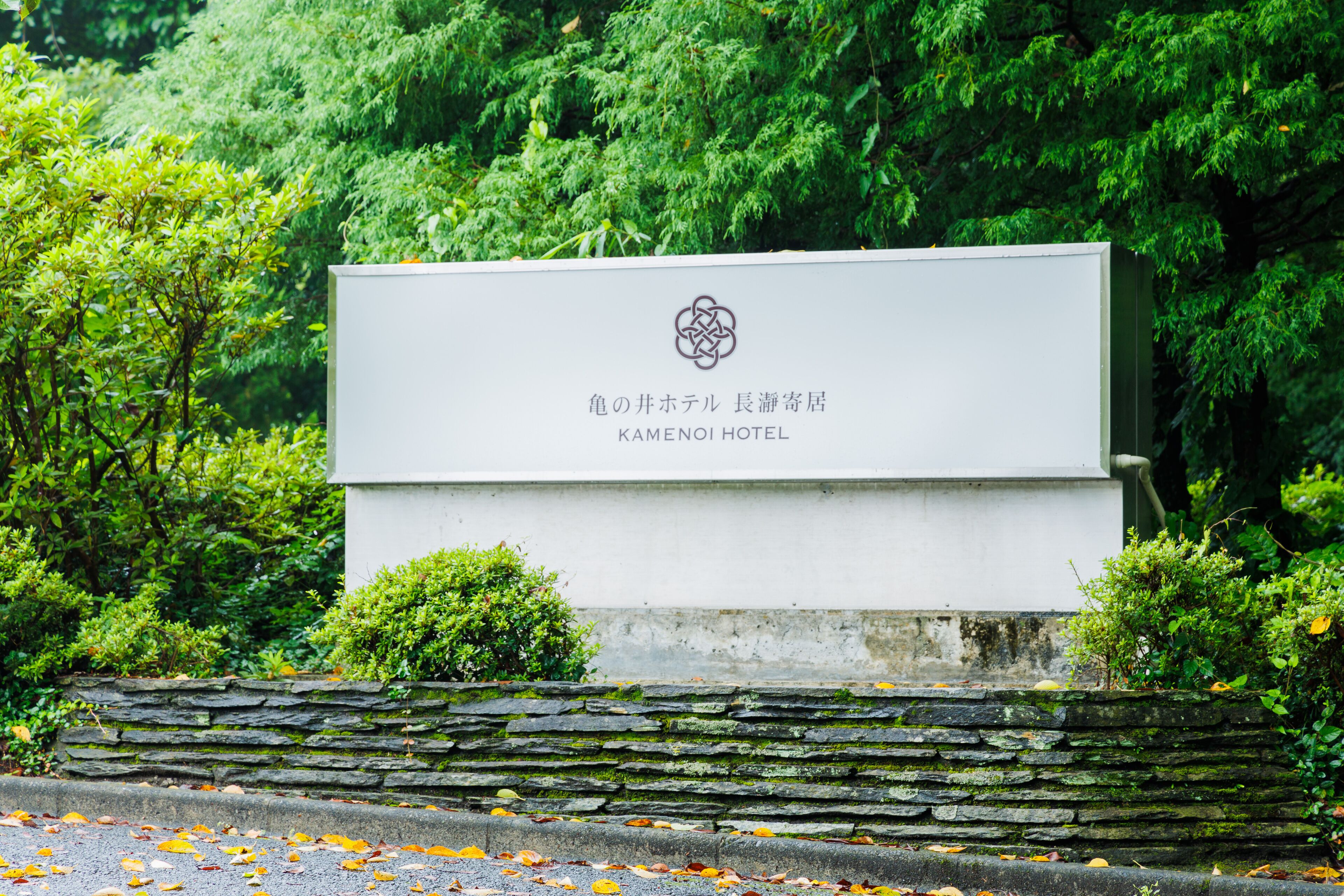 Une enseigne pour l’hôtel Kameno, avec un logo et du texte en japonais.