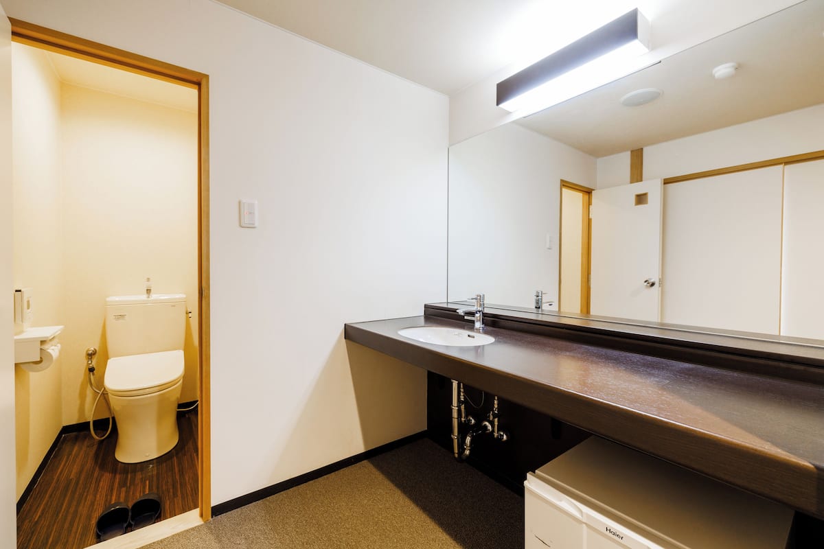 Une salle de bain moderne équipée de toilettes, d’un lavabo et d’un miroir.