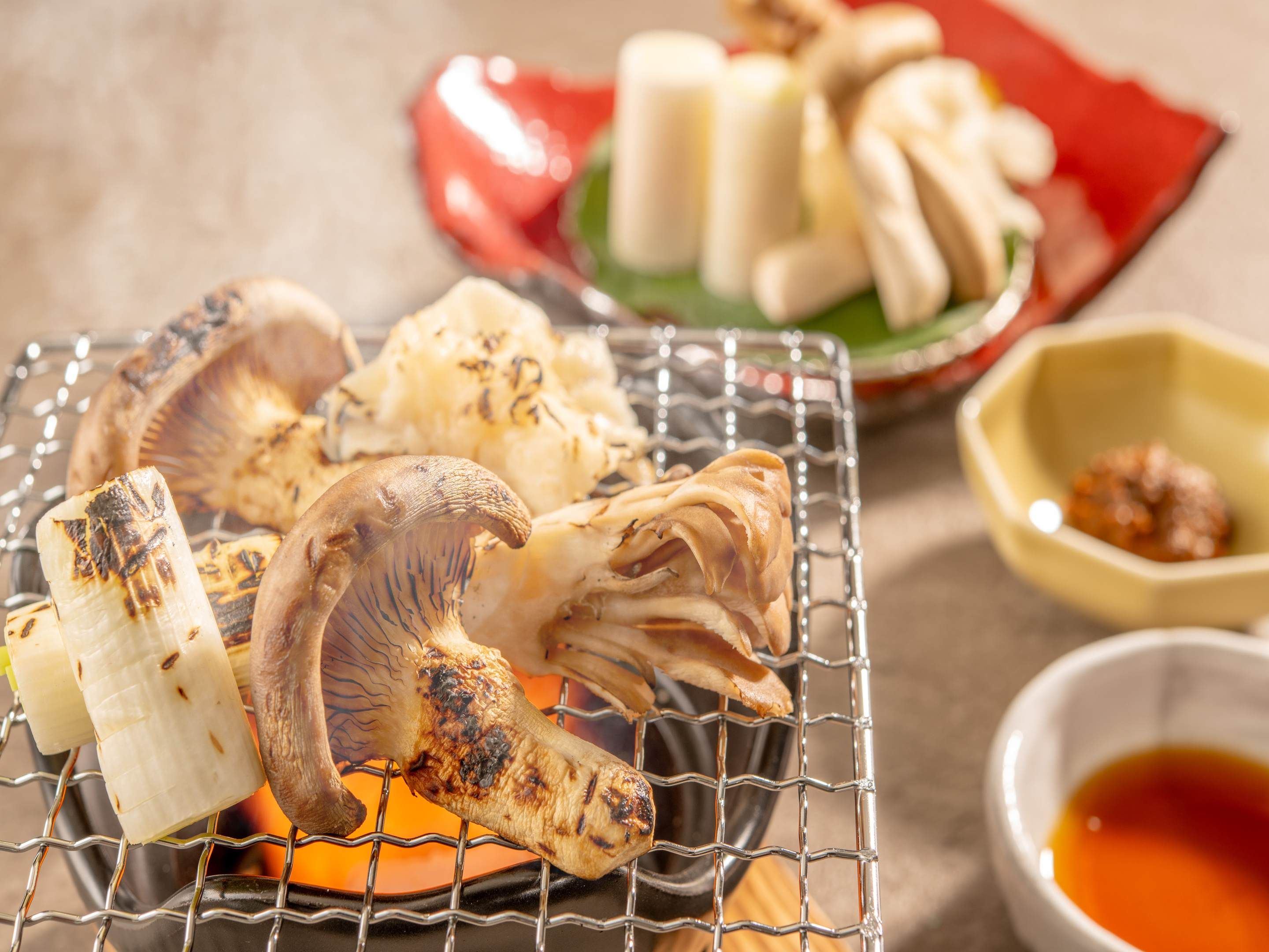 Gebratenes Essen, darunter Pilze und möglicherweise Fleisch, auf einem Drahtrost serviert.