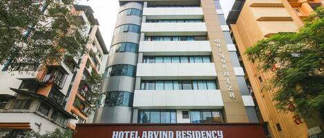 A multi-story building with a sign reading "HOTEL ARVIND RESIDENCY".