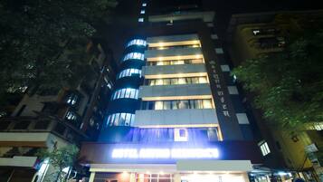 A multi-story hotel with illuminated signage and a modern facade.