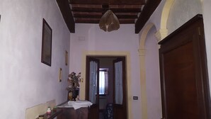 A hallway with a wooden ceiling, a door on the right, and a window at the end. - Affittacamere Ferrari (Pescaglia)