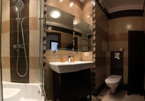 A modern bathroom with a glass-enclosed shower, a white sink, and a toilet. - Apartament F&J 12 (Torun)