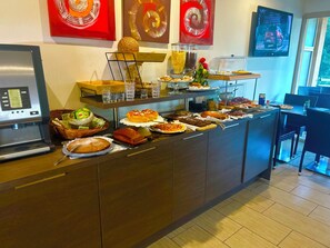 A buffet with various food items, a laptop, and a television on a counter. - Hotel Costa Rossa (Ota)