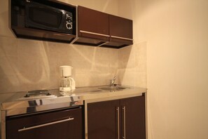 A compact kitchen with a microwave, coffee maker, and sink. - Hotel Costa Rossa (Ota)