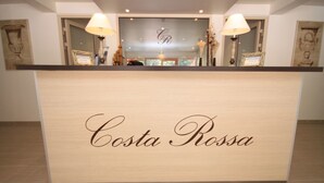 A reception desk with the name "Costa Rossa" prominently displayed. - Hotel Costa Rossa (Ota)