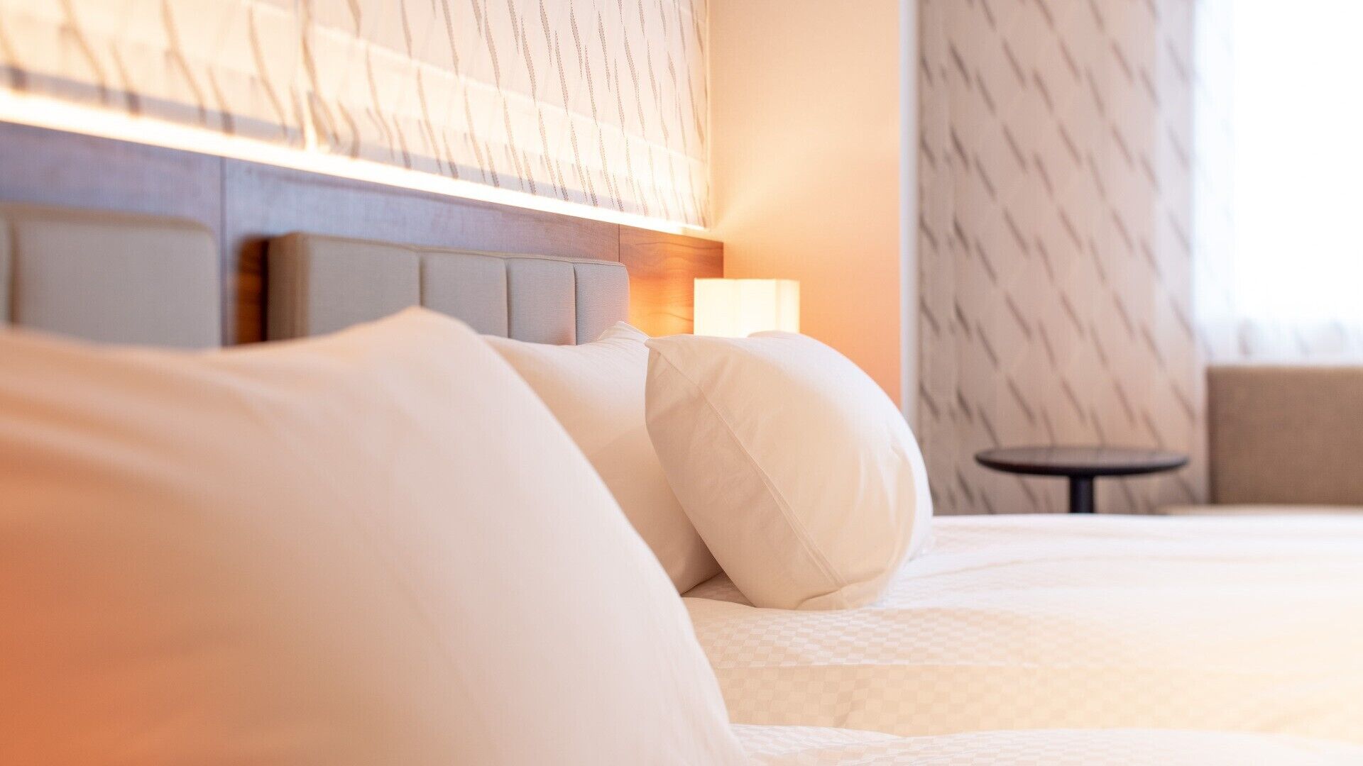 Ein Hotelzimmer mit einem Bett, einem Nachttisch und einem kleinen Tisch.