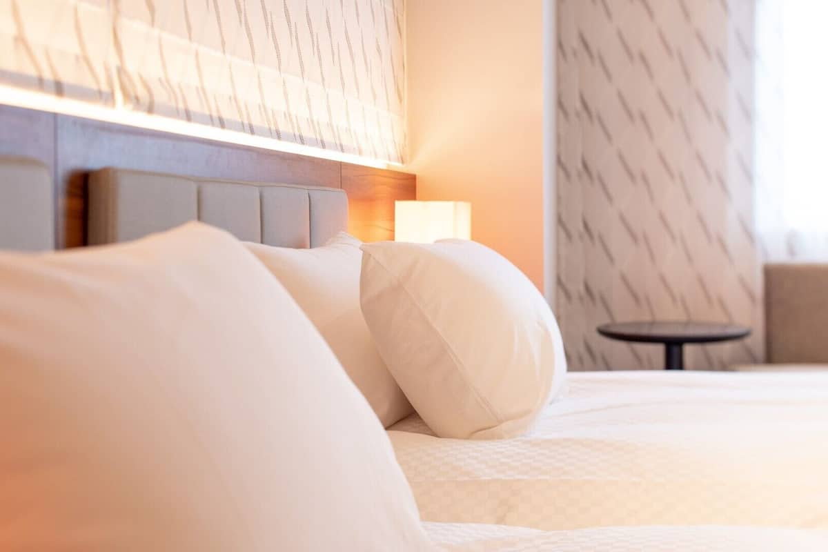 Una habitación de hotel con una cama, una mesita de noche y una pequeña mesa.