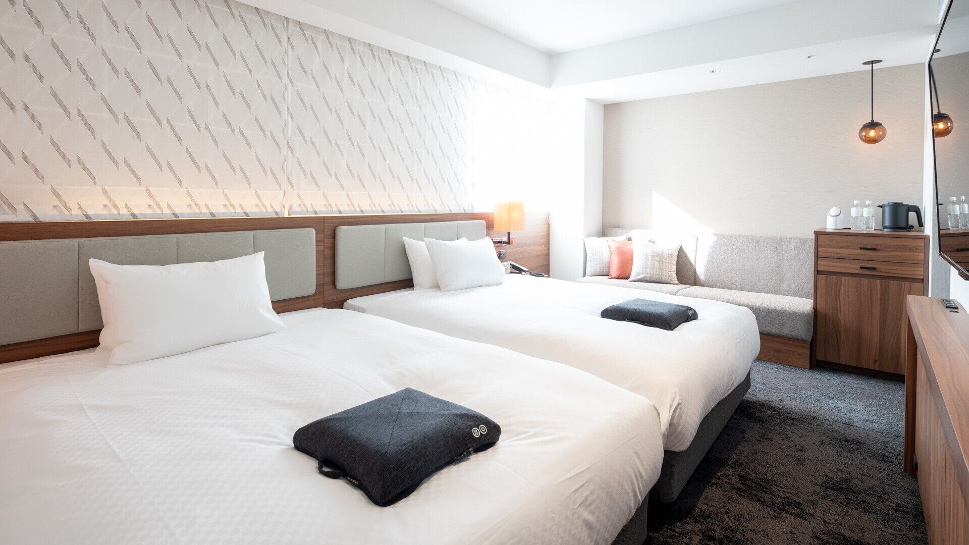 Une chambre d’hôtel avec deux lits, un canapé, un bureau et une armoire.