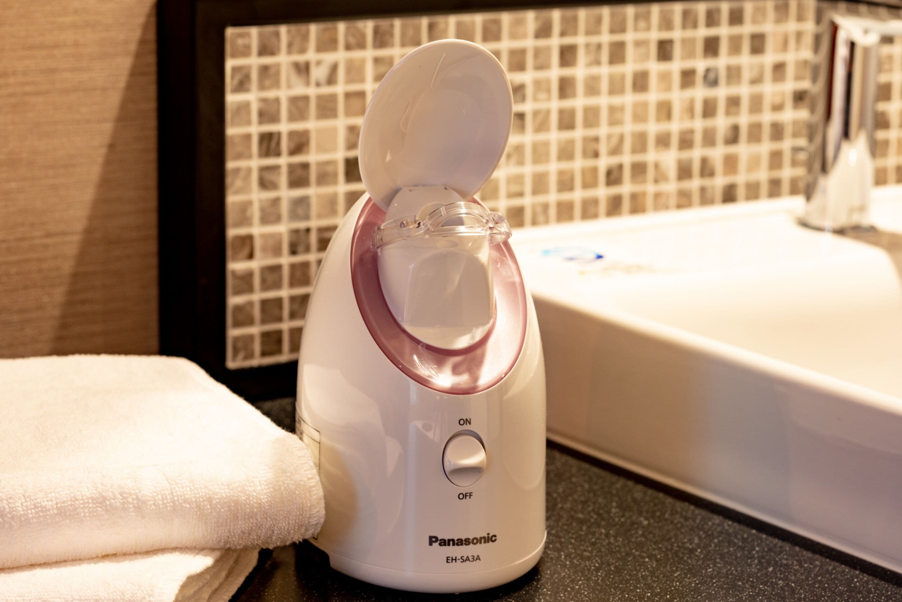 A Panasonic EH-SA3A electric kettle on a countertop with a tiled backsplash and a sink in the background.