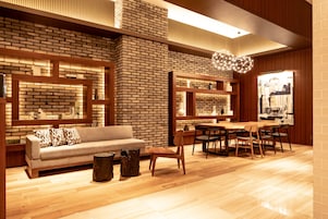 Un interior moderno con pared de ladrillo, muebles de madera y un comedor.