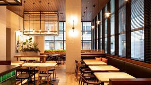A restaurant interior with wooden tables and booths, large windows, and hanging pendant lights. - Hotel Forza Hakataeki Chikushi - Guchi II (Fukuoka)