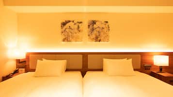 A double bed with two pillows, a nightstand with a lamp, and a wall-mounted artwork.