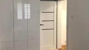 A room with a wardrobe, a door, and a light fixture. - Apartament Przy Skarpie (Torun)