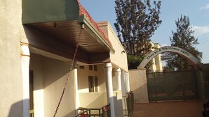 A building with a covered entrance, a sign reading "Thanks & We Come again," and a gated entrance. - Plata Guest House (Kigali)