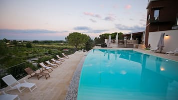 Una piscina al aire libre de temporada, sombrillas