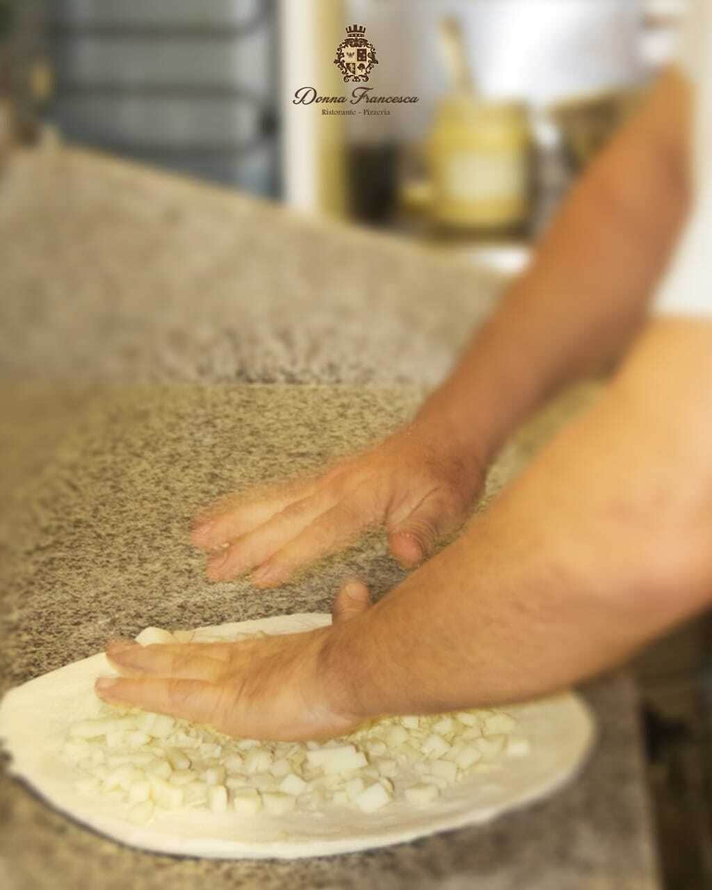 Une personne qui prépare des aliments, plus précisément qui hache des ingrédients sur une assiette.