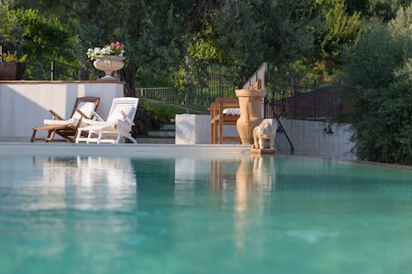 Una piscina al aire libre de temporada, sombrillas