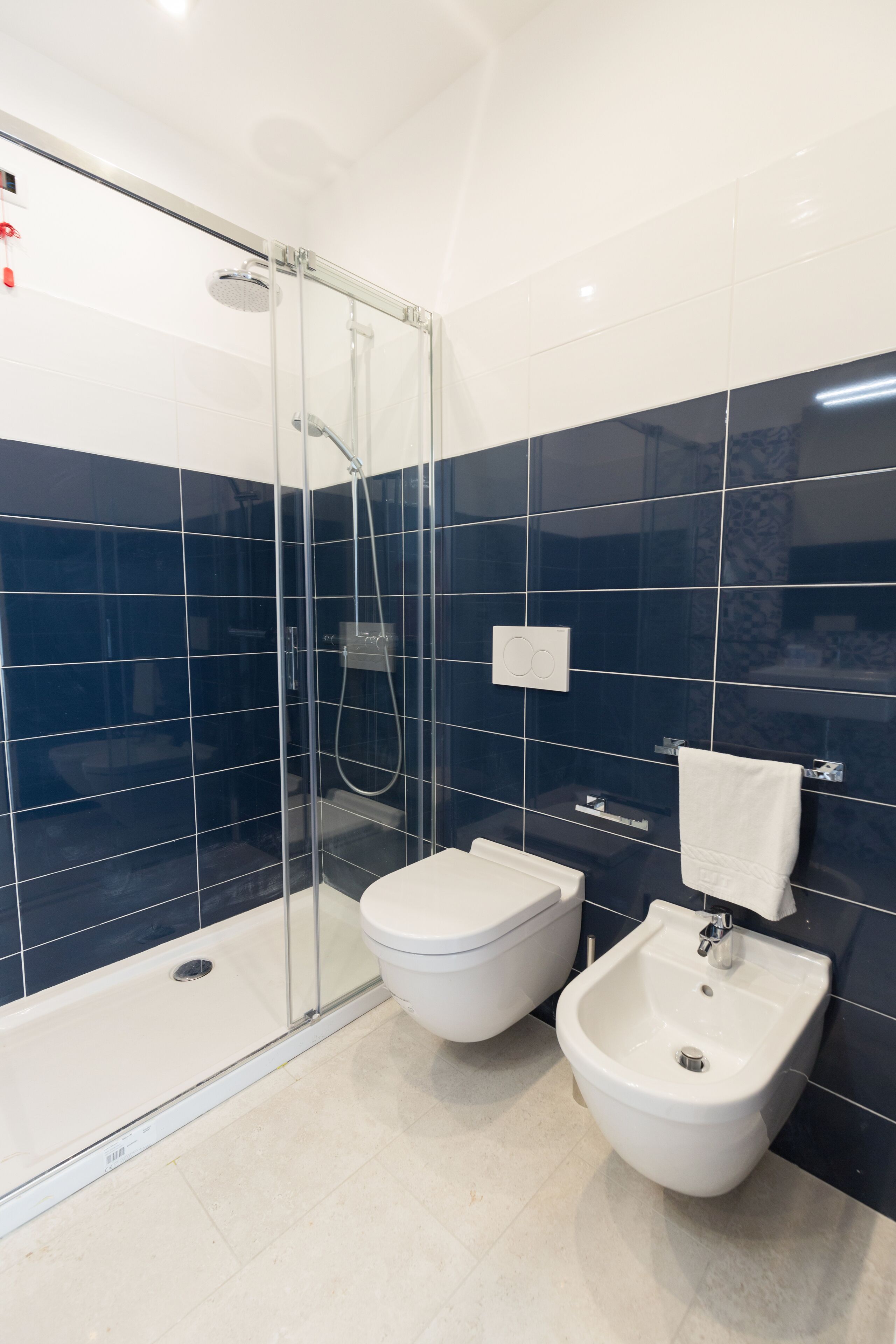 Un baño moderno con ducha de vidrio, inodoro y bidé.