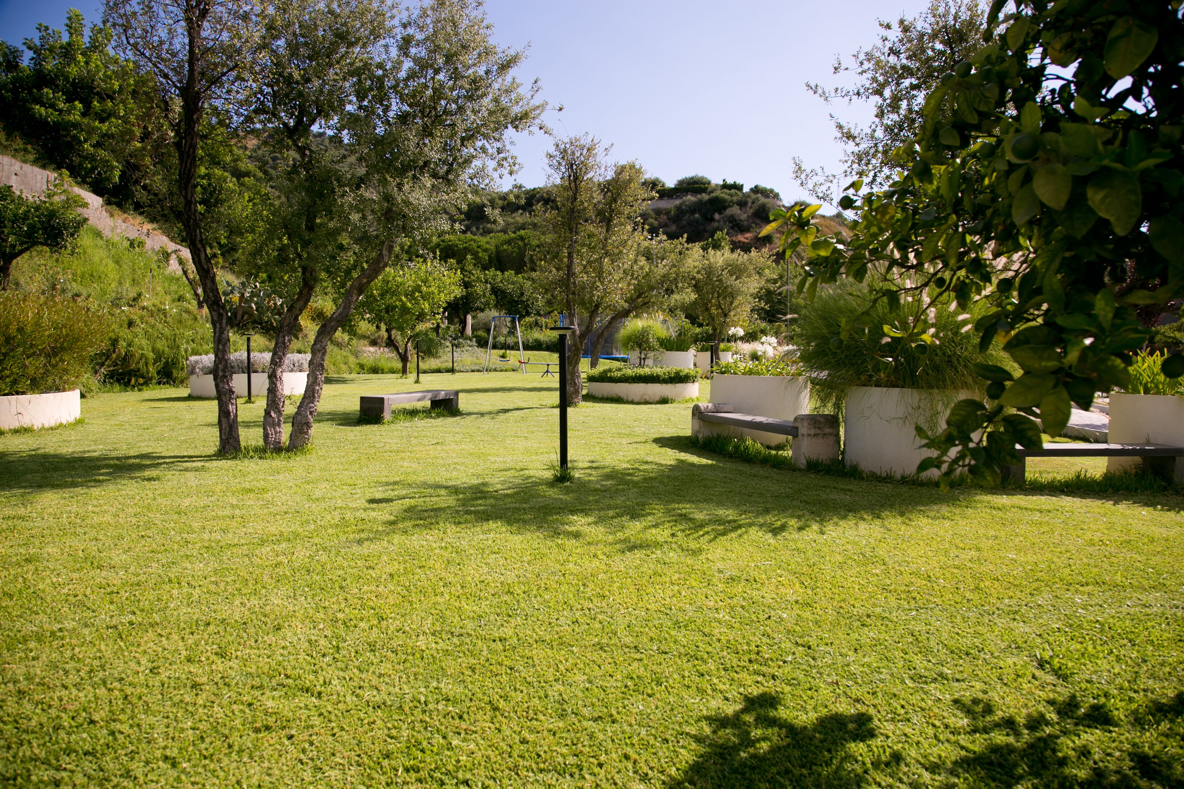 A well-maintained garden with seating areas and trees.