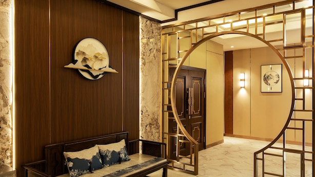 A wooden bench with cushions, a wall-mounted decorative piece, and a spiral staircase with a metal railing. - Royal house hotel (Ulaanbaatar)