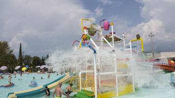 Parque acuático con tobogán de agua, piscina y diversas atracciones acuáticas.