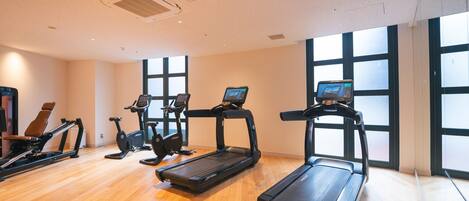 A gym with treadmills, elliptical machines, and a rowing machine.