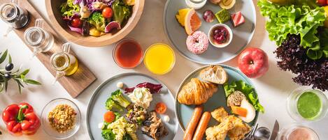 A table with various food items, including salads, fruits, vegetables, and drinks.