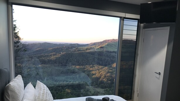 Un dormitorio con un ventanal que ofrece vistas a un paisaje montañoso.