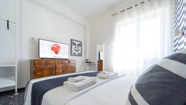 Een hotelkamer met een bed, een houten dressoir, een flatscreen televisie en kunst aan de muur.