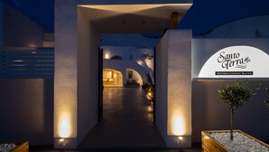 A modern building entrance with a sign reading "Santo Terra Antiguo Luxury Suites." - Santoterra Antigua Suites (Santorini)