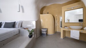 A modern bathroom with a bathtub, a sink, and a mirror. - Santoterra Antigua Suites (Santorini)