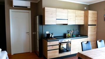 A compact kitchen with wooden cabinets, a built-in oven, and a sink.