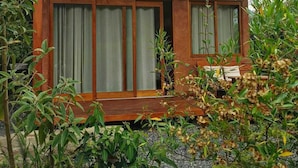 A wooden building with large windows and a covered porch area.