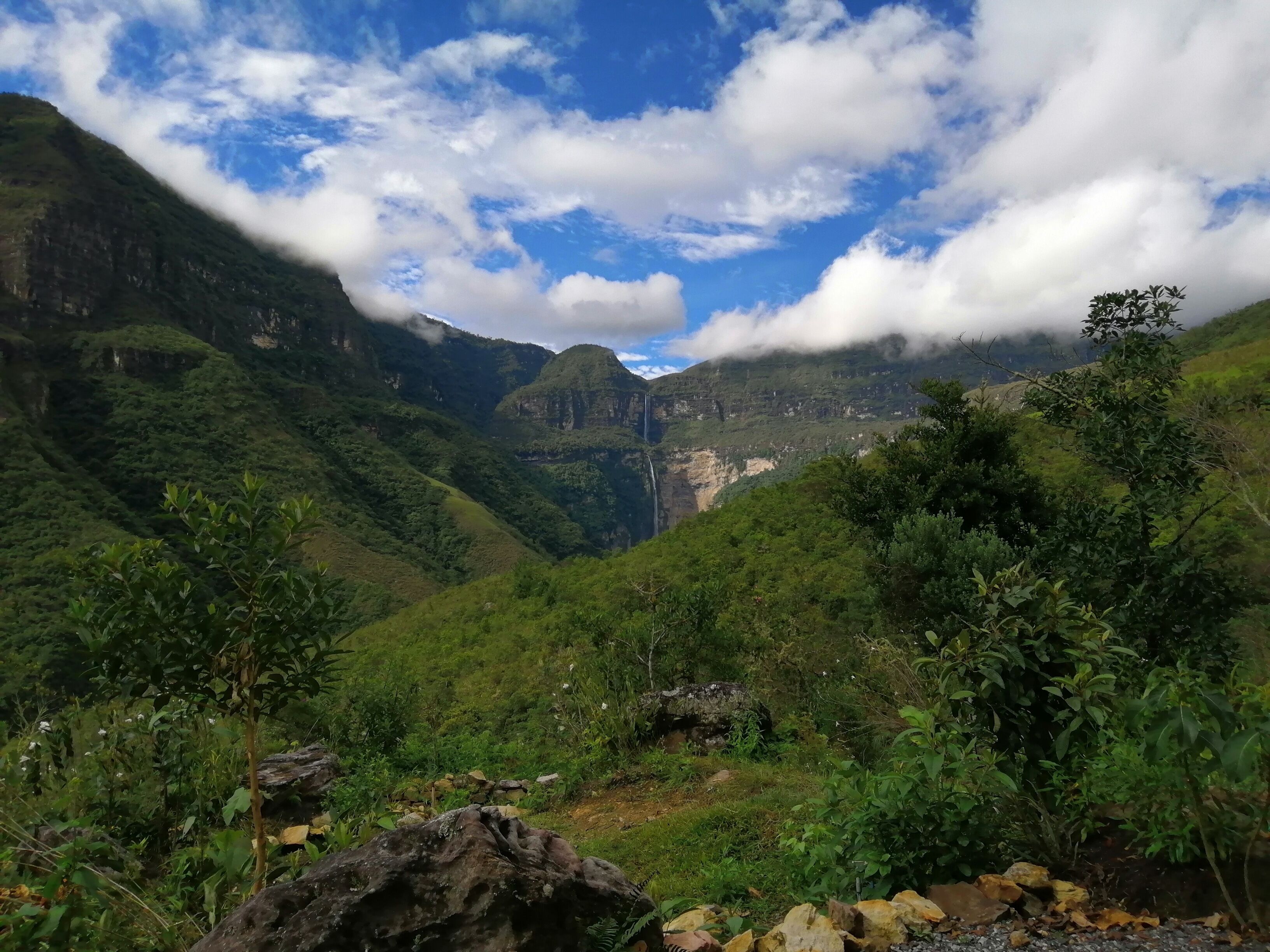 Paisatge muntanyós amb vegetació abundant i una cascada.