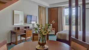 A hotel room with a wooden desk, a TV, a bed, and a large window. - Mansion Garden Hotel (Olongapo)