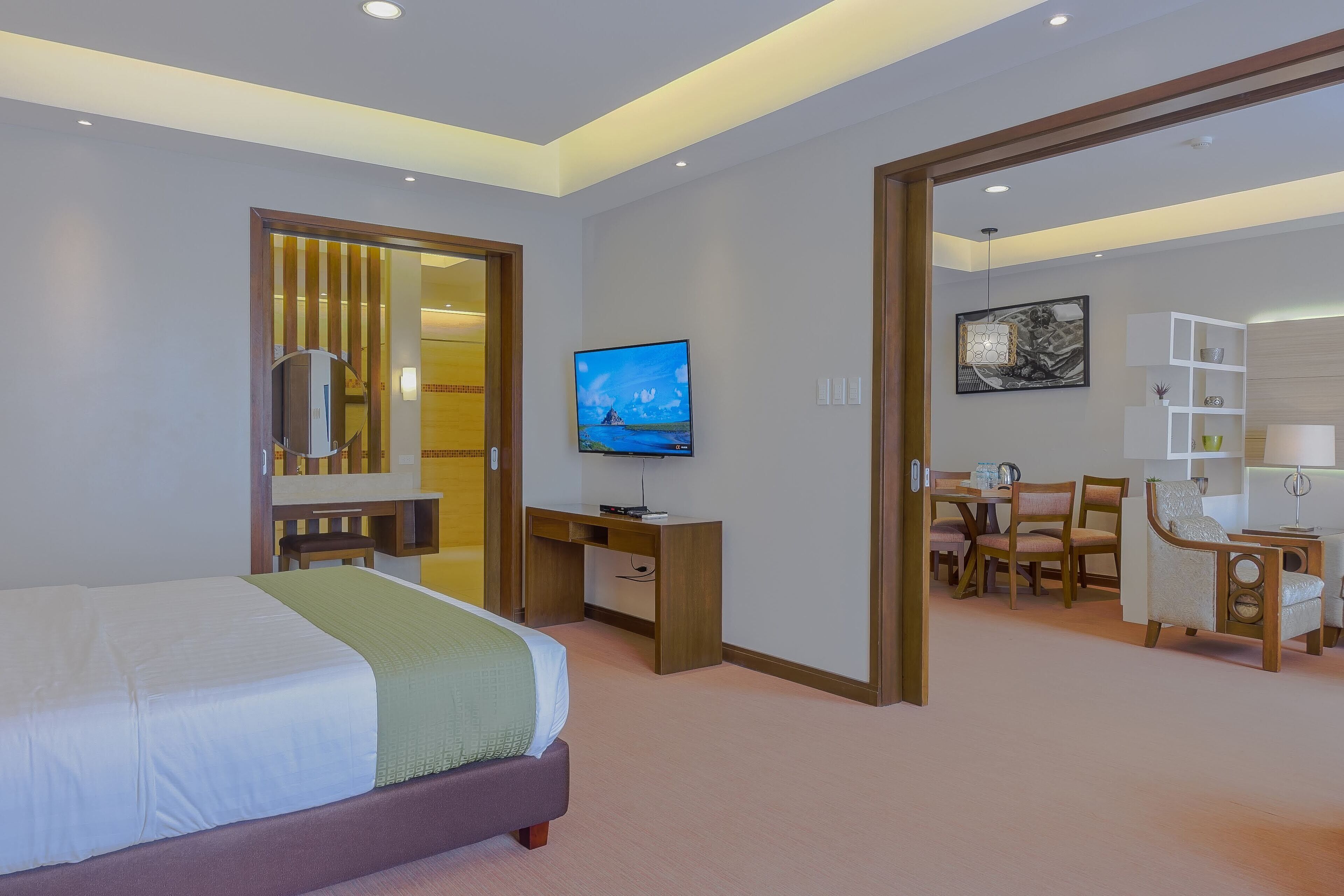 Une chambre d’hôtel comprenant un lit, un bureau, une télévision et un coin repas.