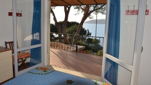A room with a view of the sea, a wooden deck, and a window with a curtain. - Ripa Dei Carrai (Capoliveri)